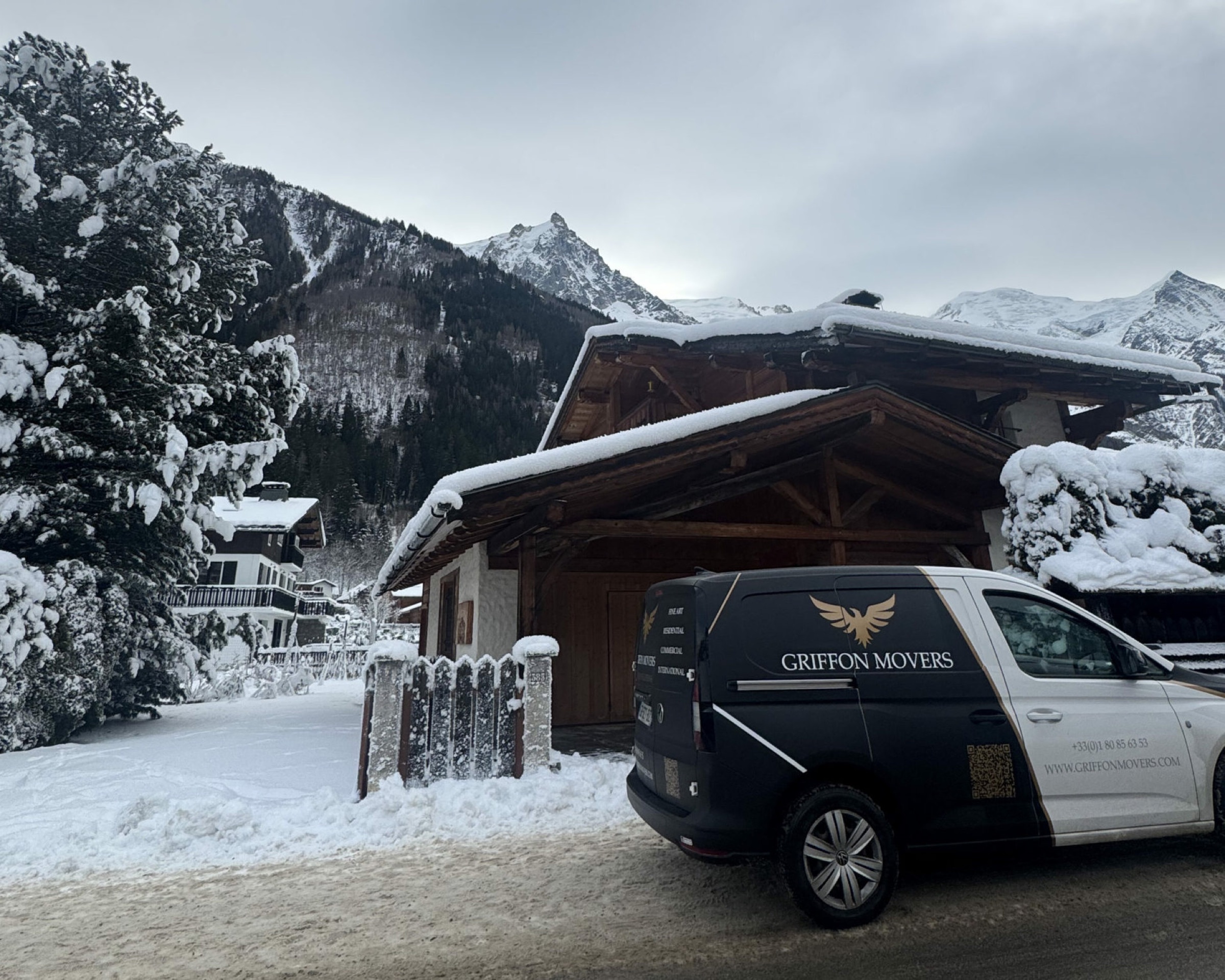 Camion Griffon Movers stationné devant un chalet alpin enneigé à Courchevel, intervention internationale Haute-Savoie